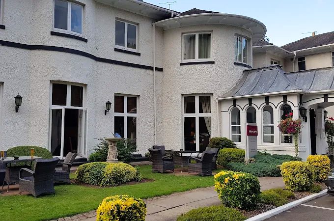 The hotel's white bay-fronted wing with garden seating on the terrace