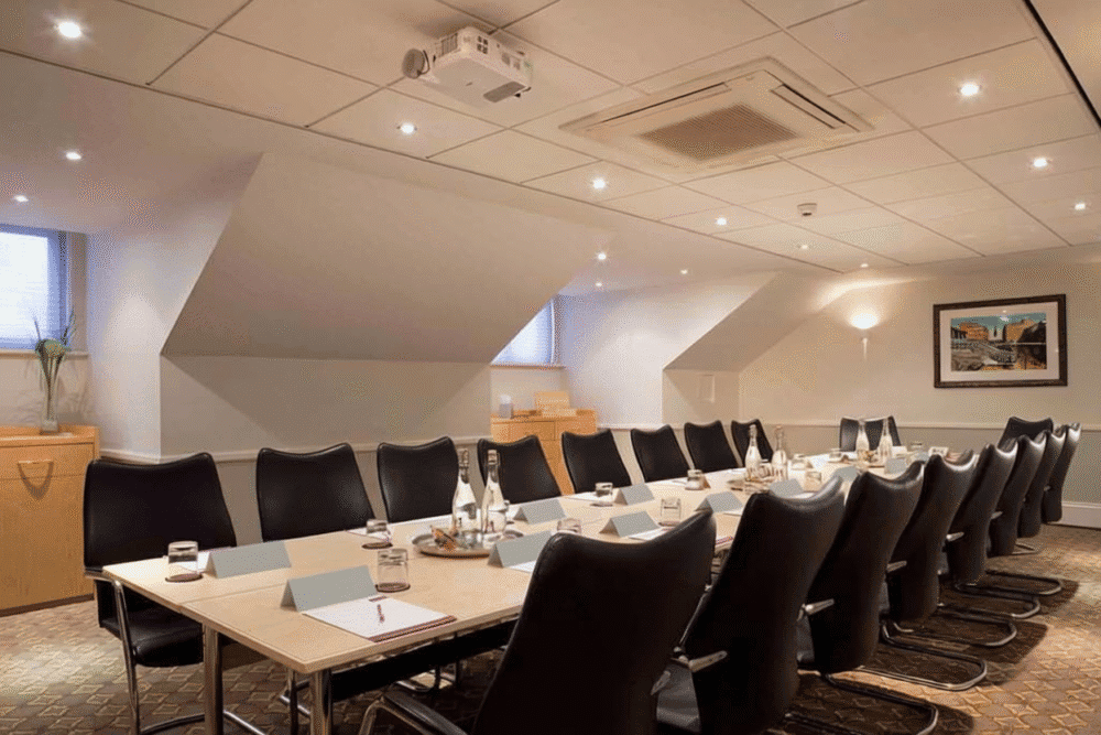 A meeting room set with seating and a presentation screen