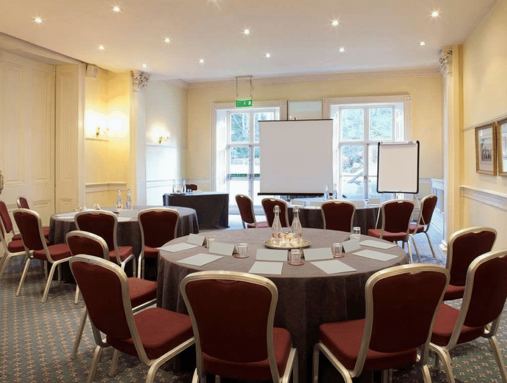 A conference room with round tables, presentation boards and natural light