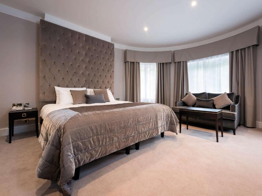 A junior suite with a large bed and a bay window