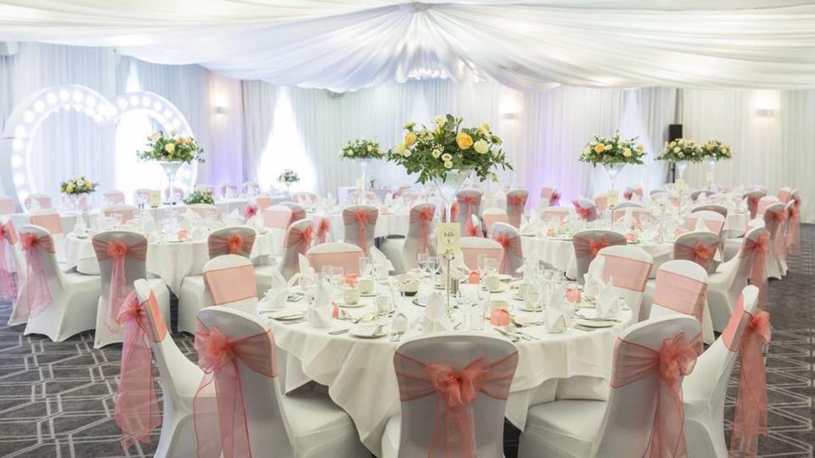 A function suite laid with round tables, white linen and flowers