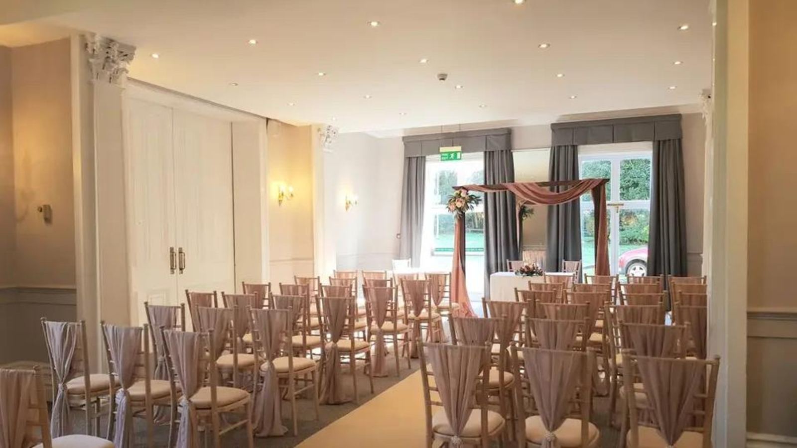 A function suite set for a ceremony with rows of chairs and an aisle