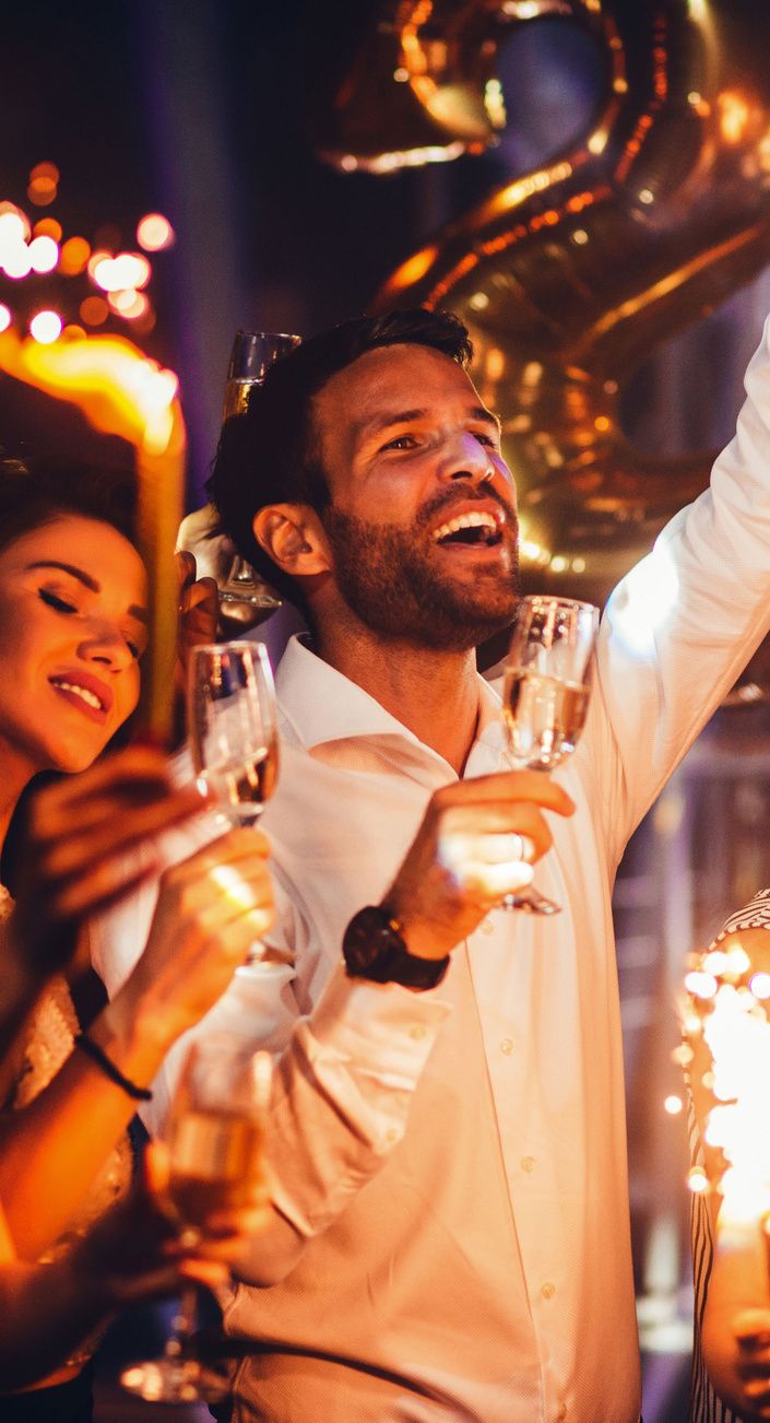 A guest celebrating at a party with lights behind