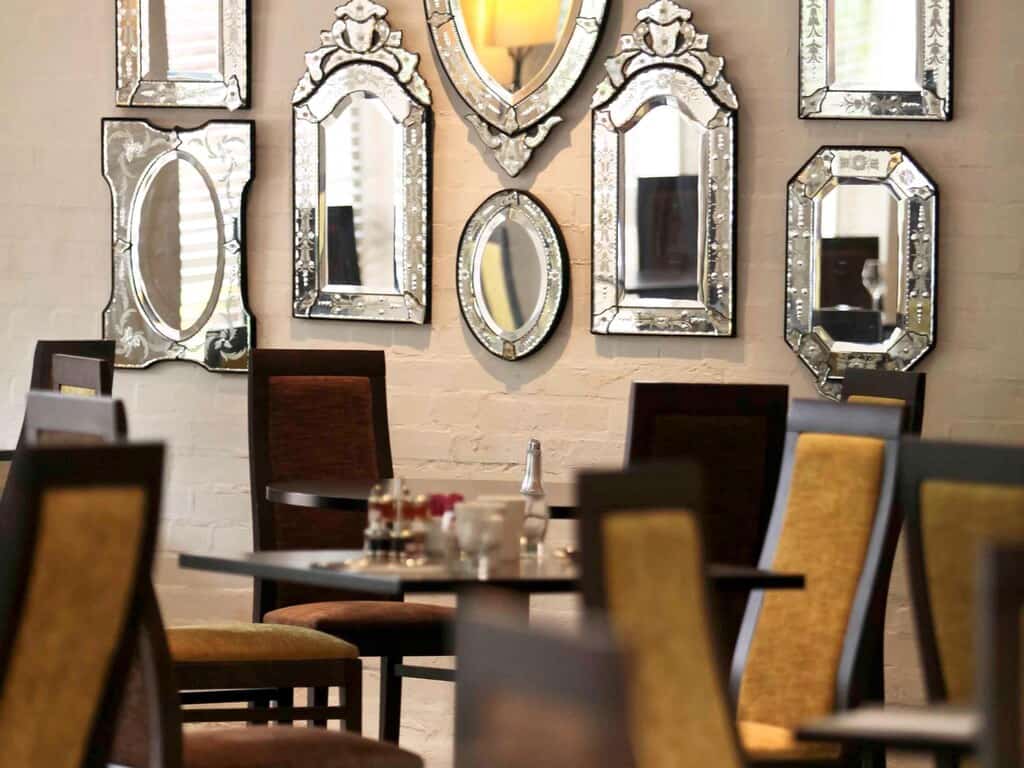 Luxurious hotel restaurant with stylish mirrors and ambient lighting.