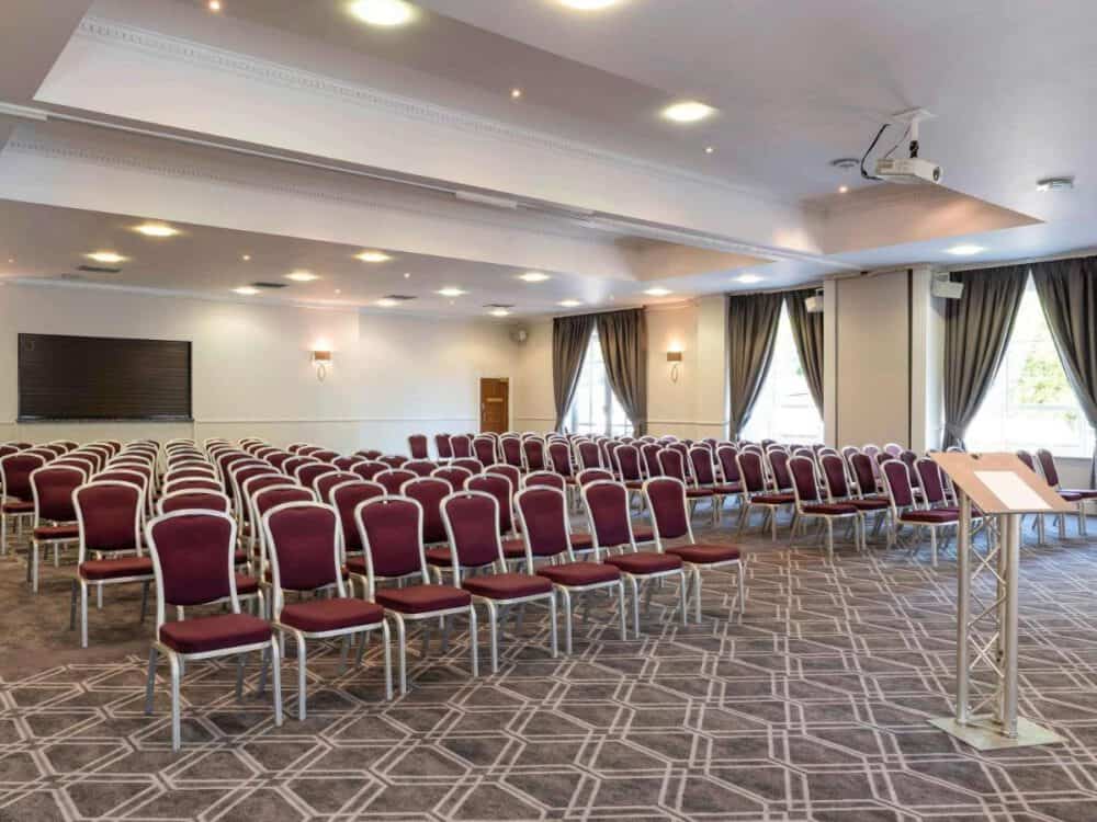 Spacious banquet hall with comfortable seating, ideal for corporate events and conferences.