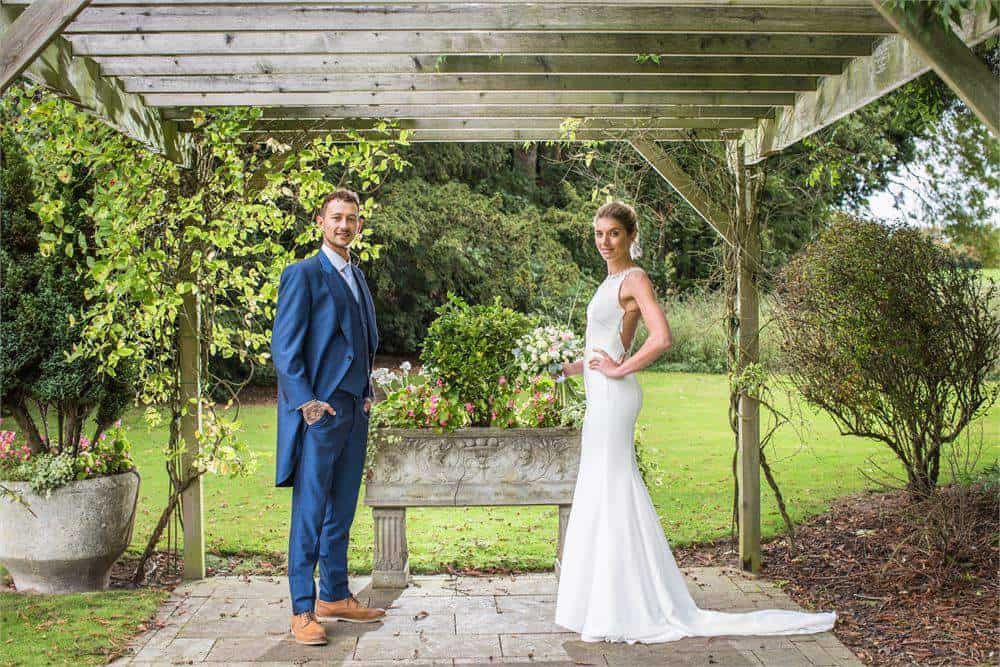 Beautiful bride and groom outdoors at Brandon Hall Hotel & Spa, showcasing wedding venue and garden scenery.